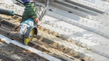 Arbeiter benutzen Schleifsteine, schneiden, befestigen Stahldächer. foto