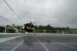 Energiefrau, die auf einem Dach mit Sonnenkollektoren arbeitet. foto