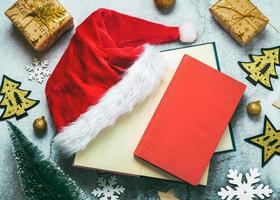 Frohe Weihnachten. Draufsicht auf Bücher, Weihnachtsgeschenke, Weihnachtsschmuck und Weihnachtsmütze. weihnachtskonzept hintergrund foto