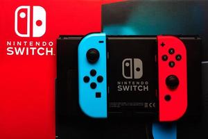 Nintendo Switch-Videospielkonsolenbox mit Nintendo Switch-Logo, Rückseite von Nintendo Switch und zwei Joy-Cons foto