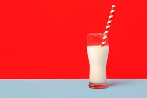 glas milch und ein rot-weißer trinkhalm mit kopierraum foto