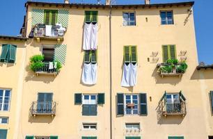 Wand aus bunten Gebäuden mit Fensterläden und trocknender Bettwäsche auf der Piazza dell Anfiteatro foto