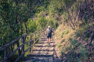 touristin wandert den fußgängerweg zwischen den dörfern corniglia und vernazza hinunter foto