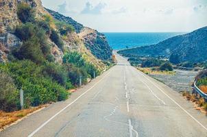 asphaltierte Küstenstraße zwischen Hügeln, die zum Mittelmeer führen foto