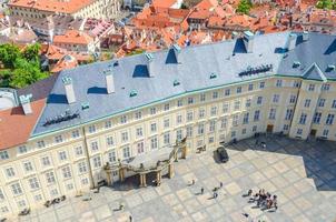 Blick von oben auf den Hofplatz der Prager Burg und den alten Königspalast mit kleinen Figuren von Wanderern foto