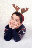 glückliches kind mit tragendem rentier in weihnachten foto