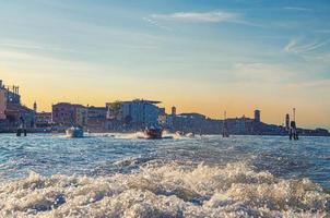 Yachtboote, die auf dem Wasser der venezianischen Lagune zwischen Holzpfählen segeln foto