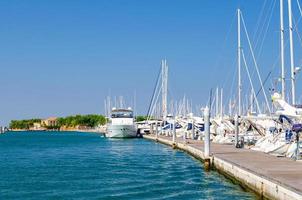 Weiße Yachten sind auf dem Wasser des Pierparkplatzes im Yachthafenhafen der Stadt Sottomarina festgemacht foto