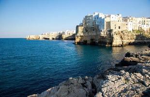 weiße gebäude auf grotten und felsen in der stadt polignano a mare in apulien foto