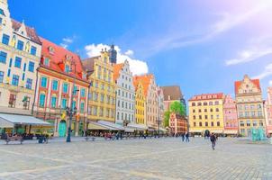 Reihe farbenfroher traditioneller Gebäude mit bunten Kunstfassaden und wandelnden Menschen auf dem Rynek-Marktplatz foto