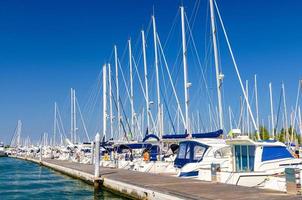 Weiße Yachten sind auf dem Wasser des Pierparkplatzes im Yachthafenhafen der Stadt Sottomarina festgemacht foto