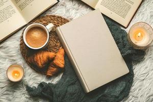 Draufsicht auf Bücher, Kaffee, Croissants und Kerzen. selektiver Fokus foto