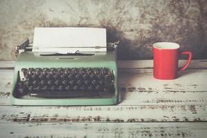 alte Schreibmaschine neben einer Tasse Kaffee foto