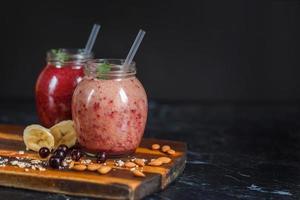 frisch zubereitete Smoothies aus Banane mit Granatapfel und Banane mit Brombeere in der Flasche. Ernährung, gesunder Lebensstil foto