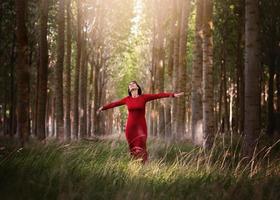 glückliches Mädchen, das das Leben und die Freiheit im Wald genießt foto