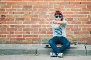 Kind mit Skateboard auf der Straße foto