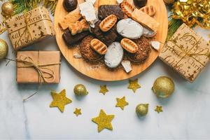 Nougat-Weihnachtsbonbon, Mantecados und Polvorones mit Weihnachtsschmuck. auswahl an weihnachtssüßigkeiten, die typisch für spanien sind foto