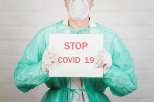 Stoppen Sie das Coronavirus. medizinischer arzt, der ein leeres brett gegen das coronavirus hält foto