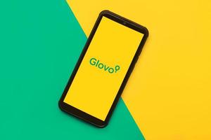 Glovo-Anwendungssymbol auf schwarzem Bildschirm des Smartphones. Essensliefer-App foto