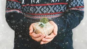 frohe weihnachten.kindhände, die ein weihnachtsgeschenk halten.weihnachtskonzepthintergrund foto