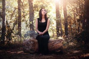 Porträt einer hübschen jungen Frau, die auf dem Feld sitzt foto