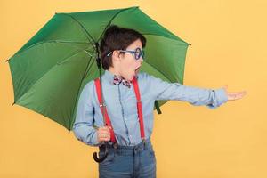 Kind mit grünem Regenschirm foto