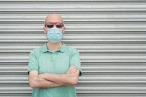 mann mit medizinischer maske mit sonnenbrille foto