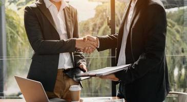 Business-Handshake, der einen Deal mit unscharfem Hintergrund von Menschen abschließt foto