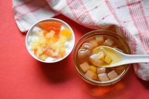 chinesische desserts, milchpudding-obstsalat und mischung von ginkgo-nüssen, maniok-sirup, kokosgelee in longansaft auf glasschale, thailändische und chinesische longan-dattelsuppe, asiatische dessertbonbons foto