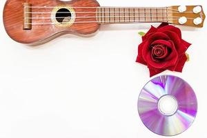 Akustikgitarre und rote Rosenblüte, isoliert auf weiß foto