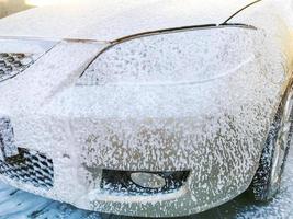 manuelle Autowäsche mit Druckwasser in der Autowaschanlage im Freien. Autoreinigung mit Hochdruckwasser. foto