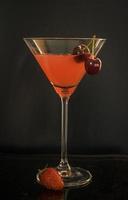ein glas roter cocktail mit sommerfrüchten foto