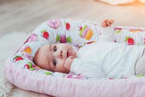 Foto charmantes neugeborenes Baby in einer rosafarbenen Wiege