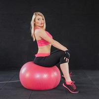 junge attraktive schlanke frau in sportbekleidung, die fitness-übungsball macht. foto