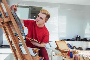 Künstler, der ein Bild in einem Studio malt foto