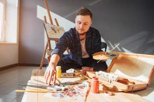 Entworfen vom Künstler Mann, der sein Meisterwerk fertigstellt, hält einen Pinsel in der Hand. foto