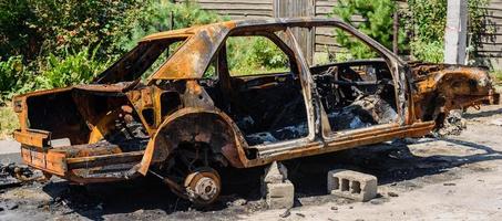 verbrannter Personenwagen auf der Straße eines dysfunktionalen Gebiets foto