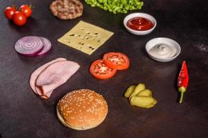 leckerer frischer saftiger burger mit rinderkotelett, käse, tomaten und zwiebeln foto