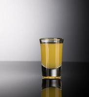 Schnapsglas mit Alkohol auf dunklem Hintergrund foto