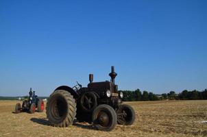 Alter Traktor auf dem Feld foto