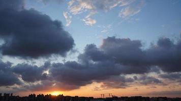 die schöne Aussicht auf den Sonnenuntergang mit der Silhouette und dem bunten Wolkenhimmel in der Stadt foto
