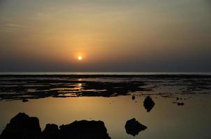 sonnenaufgang mit felsen und reflexion foto