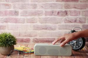 Männerhand mit Smart Speaker auf dem Tisch foto