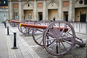 Schweden, Stockholm, 30. Mai 2018 Wachsoldat auf Posten in der Nähe einer Reihe alter Kanonen auf dem Hofplatz des schwedischen Königspalastes, offizielle Residenz des Königs von Schweden foto