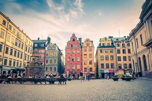 schweden, stockholm, 30. mai 2018 traditionelle typische gebäude mit bunten wänden, nobelmuseum und brunnen auf dem platz stortorget foto