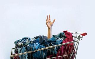 Shopaholic-Konzept. weibliche hand ragt aus einkaufswagen foto