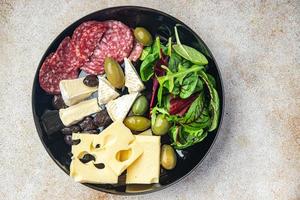 Snackteller Käse, Wurst, Oliven, Brotstangen, frische Vorspeisenmahlzeit foto