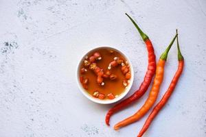 Fischsauce auf weißer Schüssel und frischem Chili auf dem Tisch, Fischsauce aus fermentiertem Fisch oder kleinen Wassertieren, fermentierte Lebensmittel foto