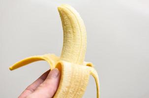 Bananenschale auf grauem Hintergrund, Nahaufnahme reife Bananenschale zur Hand foto