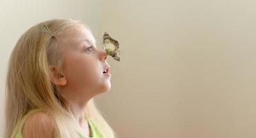 Das Mädchen blickt überrascht auf einen Schmetterling mit Flügeln von einem 1000-Dollar-Schein, der auf ihrer Nase sitzt foto